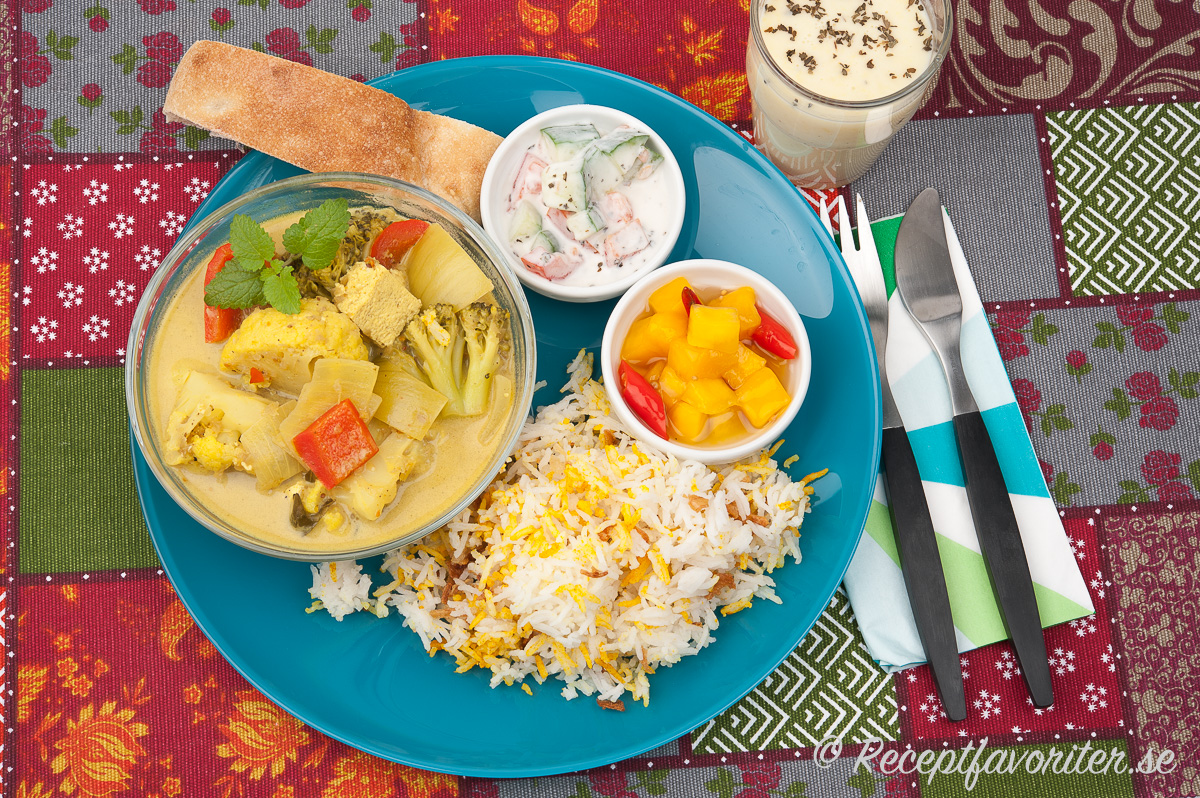 Vegansk currygryta med vegansk raita, picklad het mango och indiskt ris. Naan-bröd passar också till.