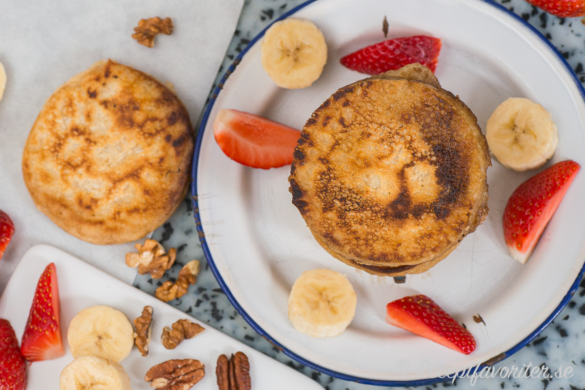 Fluffiga veganska pannkakor i amerikansk stil serverad med frukt, bär och nötter. Fluffiga veganska pannkakor i amerikansk stil serverad med frukt, bär och nötter.