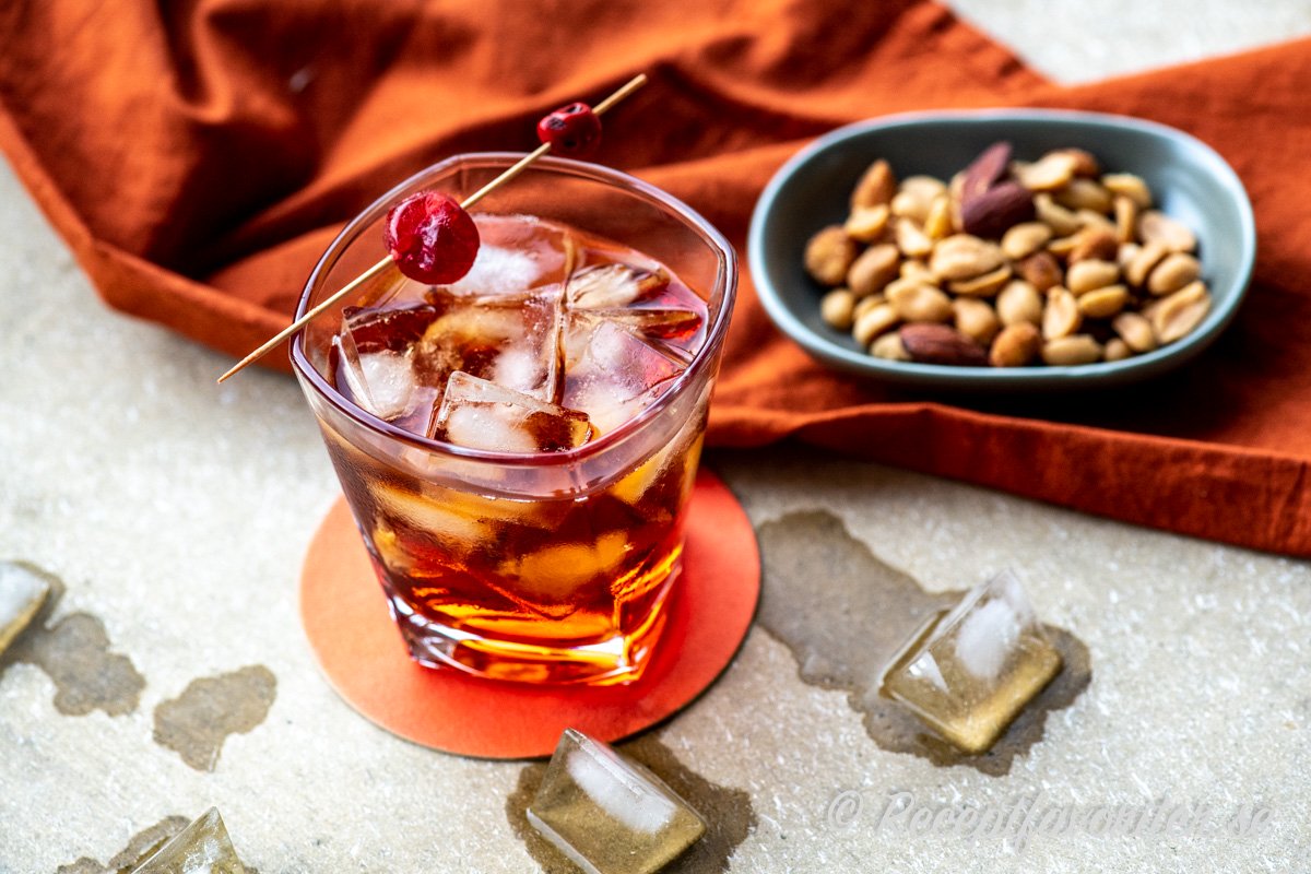 Boulevardier cocktail garnerad med ett rött cocktailbär. Boulevardier cocktail garnerad med ett rött cocktailbär.
