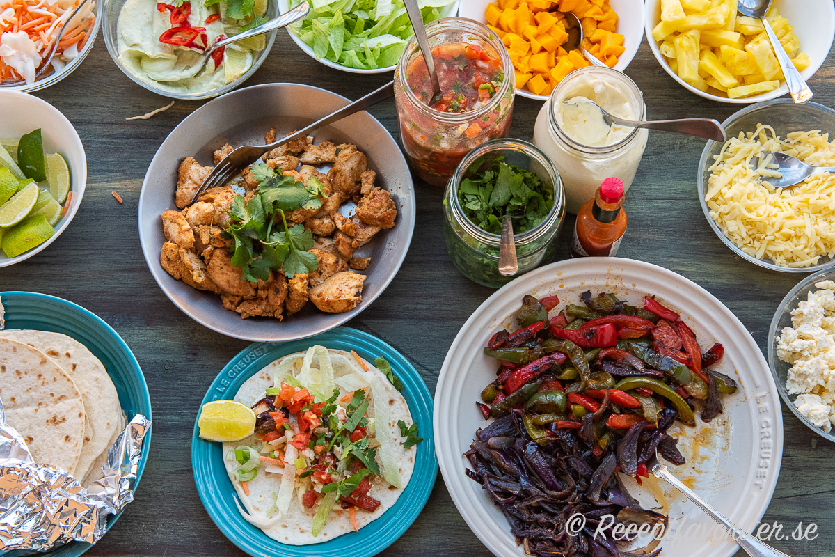 Kycklingfajitas med tillbehör serverad som en liten buffé. Kycklingfajitas med tillbehör serverad som en liten buffé.