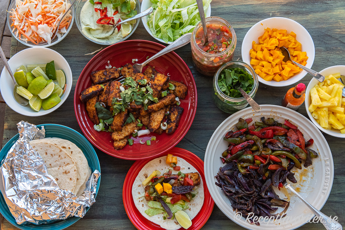 Tempeh-fajitas omgiven av goda tillbehör som en buffé Tempeh-fajitas omgiven av goda tillbehör som en buffé