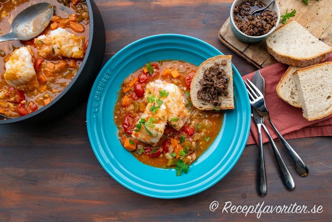 Italiensk tomatdoftande fiskgryta med lubb serverad med surdegslimpa och tapenade Italiensk tomatdoftande fiskgryta med lubb serverad med surdegslimpa och tapenade