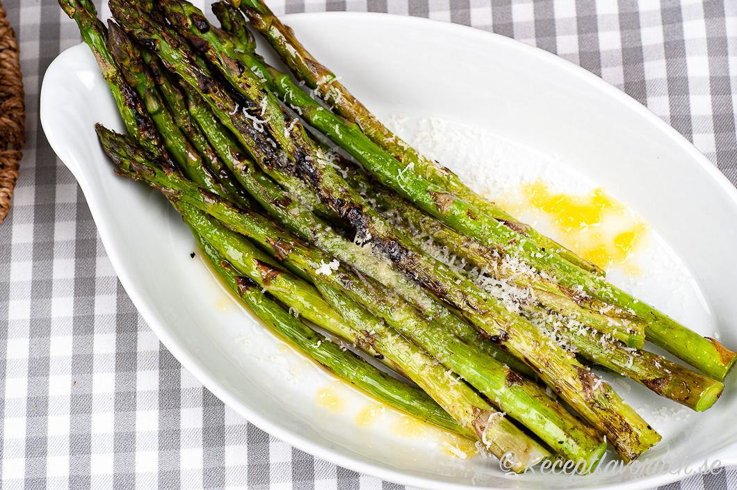 Grillad grön sparris på fat med riven parmesan och smör. Grillad grön sparris på fat med riven parmesan och smör.