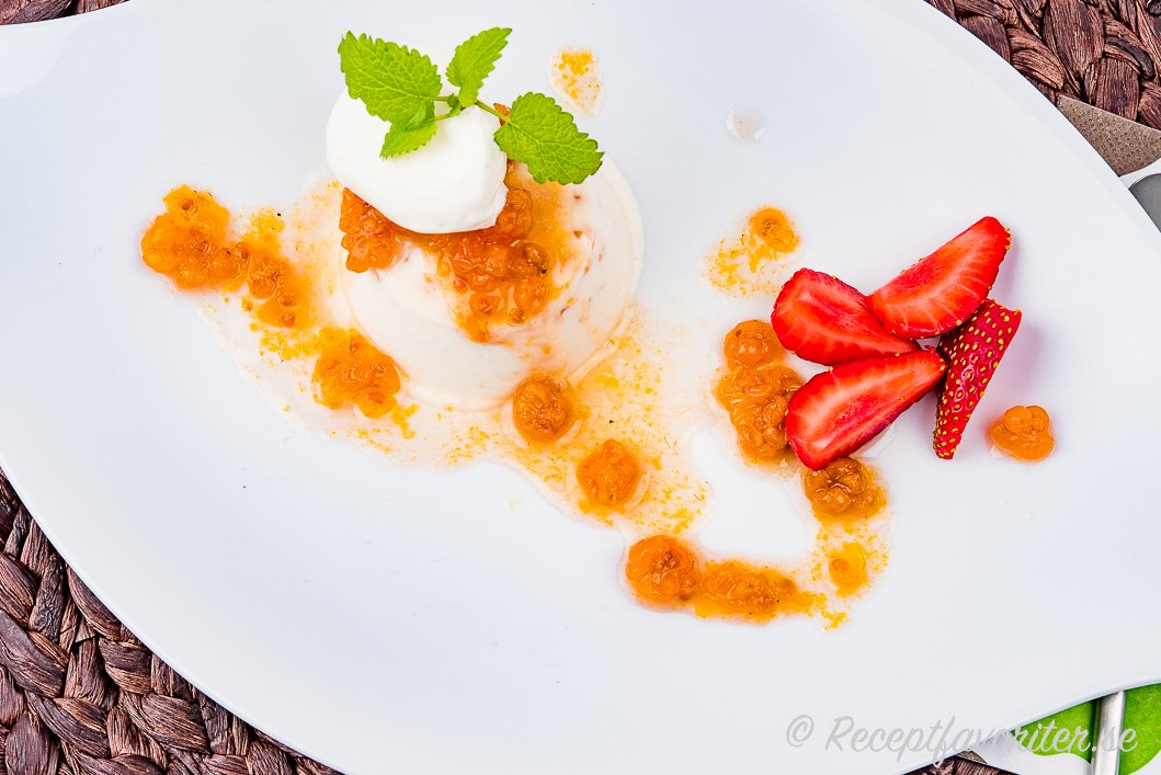 Hjortronparfait med mylta, citronmeliss, grädde, jordgubbar på tallrik. Hjortronparfait med mylta, citronmeliss, grädde, jordgubbar på tallrik.
