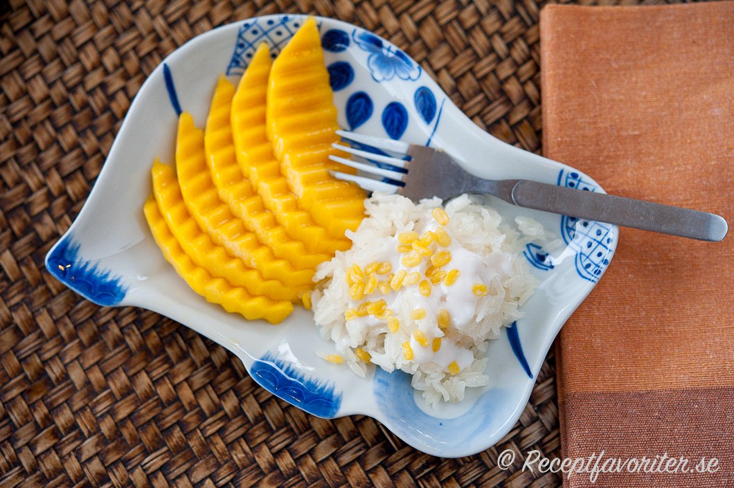 Klibbigt sticky rice med kokosgrädde och socker serverad med färsk mango på tallrik