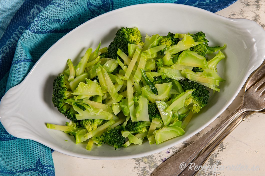 Kokt broccoli med stammen i vinäger, olivolja och salt på fat