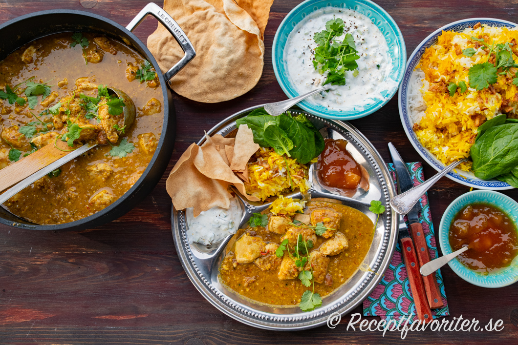 Kyckling Korma serverad med raita, ris, papadams och mango chutney. Kyckling Korma serverad med raita, ris, papadams och mango chutney.