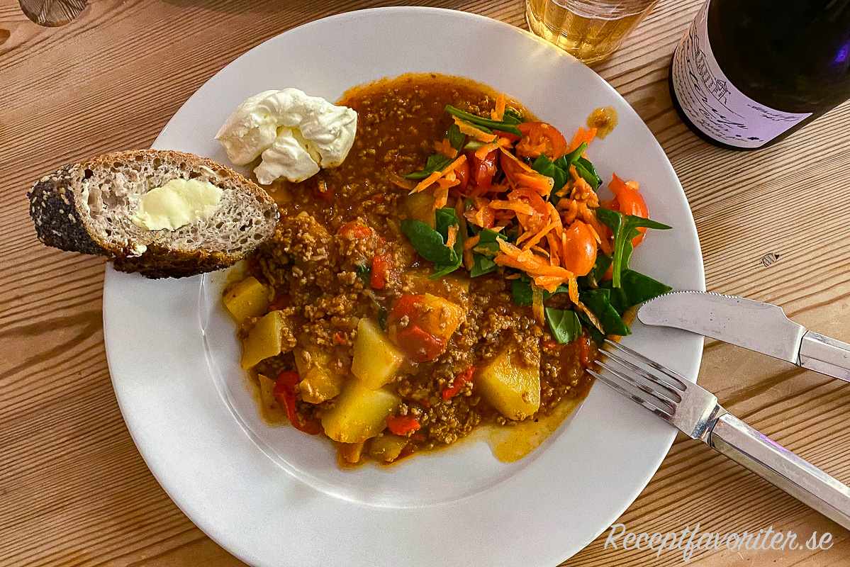 Köttfärsgrytan serverad med tillbehör - surdegsbaguette med smör, crème fraiche, sallad med hackad babyspenat, tomat och riven morot samt en torr cider från Tosterup. Köttfärsgrytan serverad med tillbehör - surdegsbaguette med smör, crème fraiche, sallad med hackad babyspenat, tomat och riven morot samt en torr cider från Tosterup.