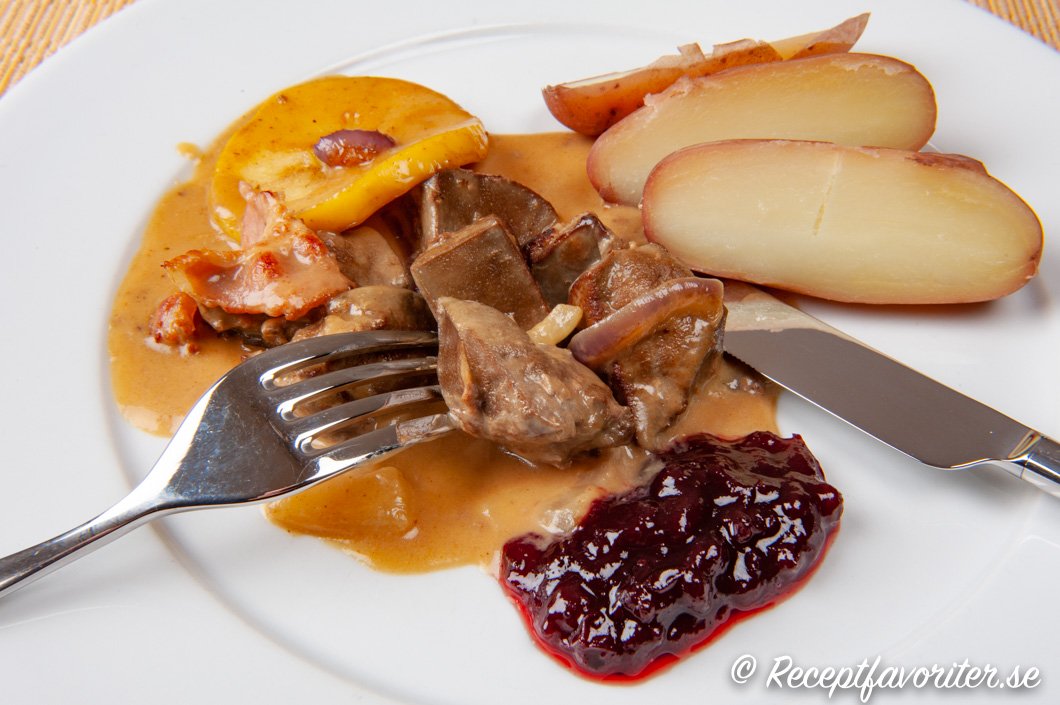 Lammlevergryta med bacon och äpple på tallrik Lammlevergryta med bacon och äpple på tallrik