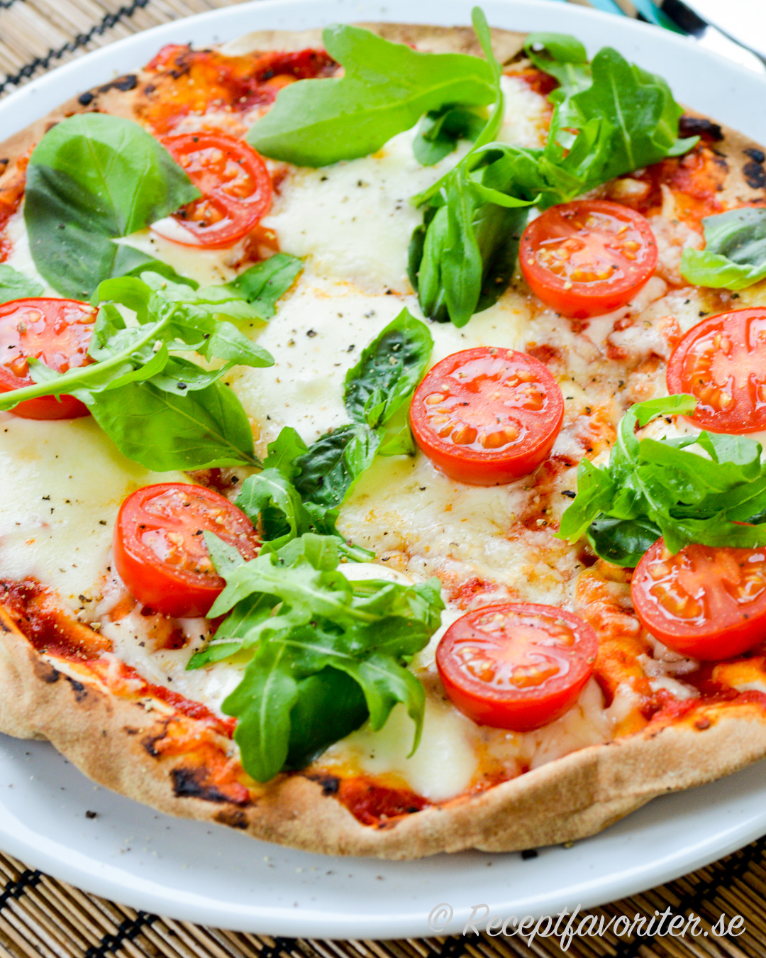 Pizza av Libabröd - arabiskt tunnbröd - toppad med mozzarella, cocktailtomater och ruccola samt basilika. Pizza av Libabröd - arabiskt tunnbröd - toppad med mozzarella, cocktailtomater och ruccola samt basilika.