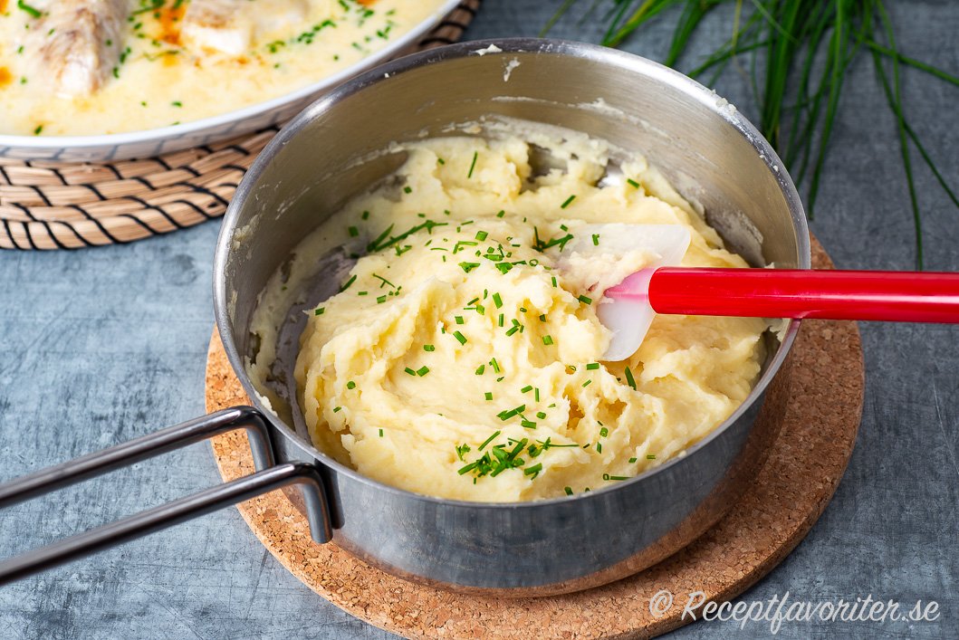 Mos av palsternacka och potatis garnerat med hackad gräslök i kastrull Mos av palsternacka och potatis garnerat med hackad gräslök i kastrull