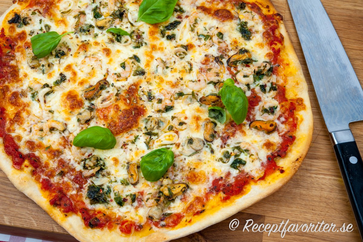 Pizza Marinara med tomat och basilika på skärbräda. 