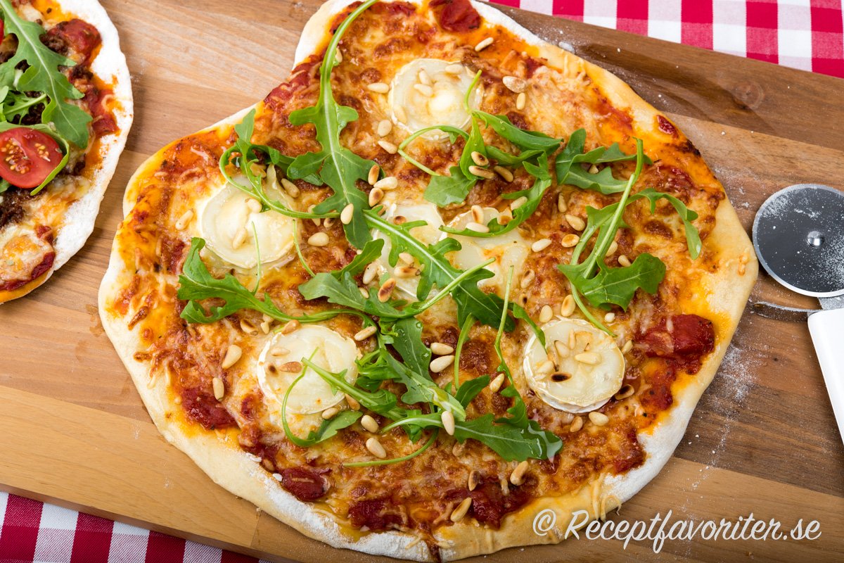 Chèvrepizza eller getostpizza på skärbräda med pizzaslizer