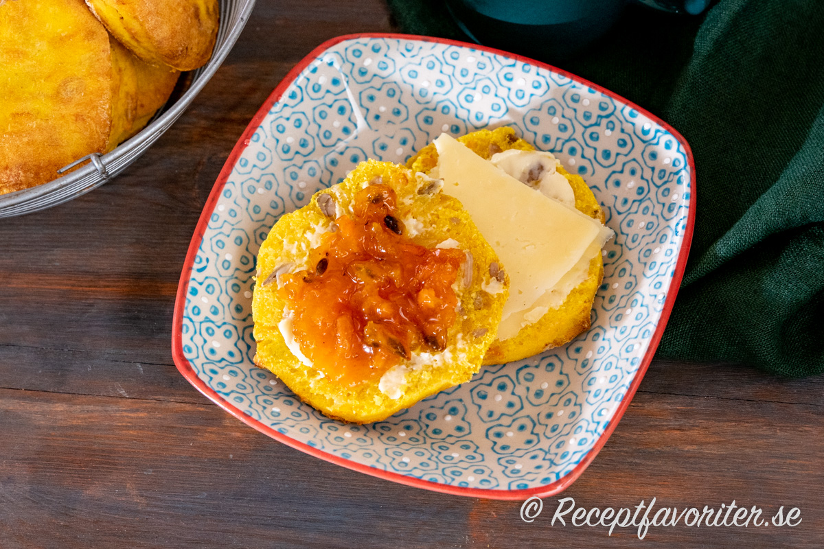Pumpascones i halvor med smör, ost och tomatmarmelad på assiette till fika. Pumpascones i halvor med smör, ost och tomatmarmelad på assiette till fika.
