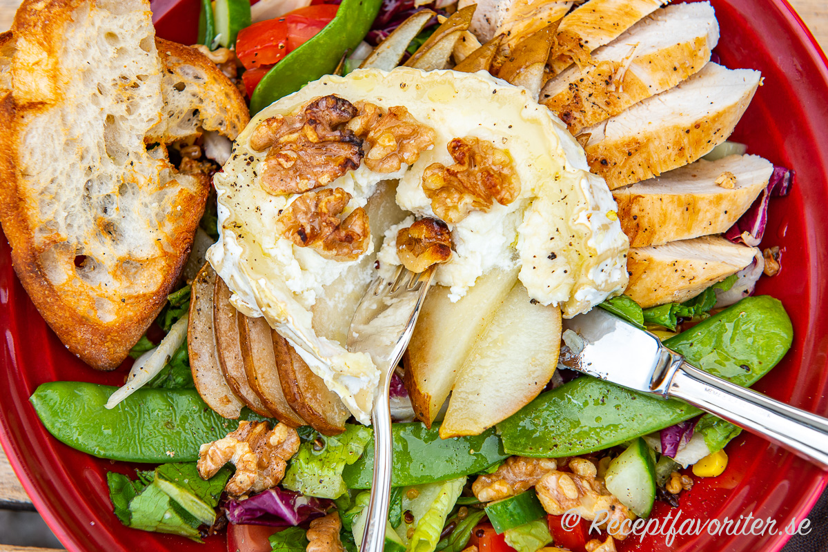 Getost eller chèvre i rulle bakad med honung, valnötter och päron blir mycket gott ihop med kycklingfilé, sallad samt enkel vinaigrette med olivolja samt äppelcidervinäger. Getost eller chèvre i rulle bakad med honung, valnötter och päron blir mycket gott ihop med kycklingfilé samt sallad på tallrik.