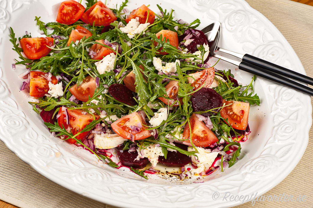 Ett fat med sallad blandad av rödbetor, mozzarella, tomater och ruccola. Ett fat med sallad blandad av rödbetor, mozzarella, tomater och ruccola.