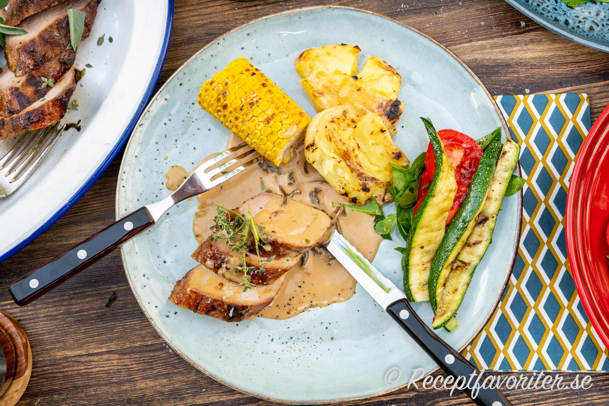 Såsen med torkade trattkantareller serverad på tallrik med grillad vildsvinsytterfilé, smashad färskpotatis, majs, zucchini och sallad av tomat och babyspenat. Såsen med torkade trattkantareller serverad på tallrik med grillad vildsvinsytterfilé, smashad färskpotatis, majs, zucchini och sallad av tomat och babyspenat.