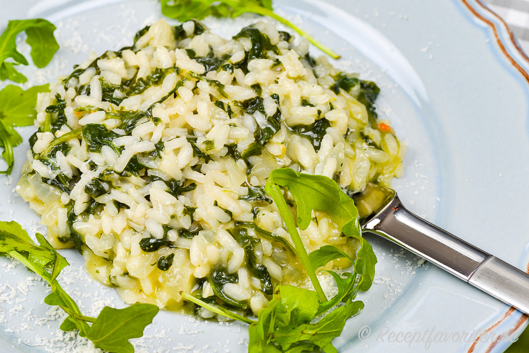 Krämig och vackert grön risotto med spenat på tallrik Krämig och vackert grön risotto med spenat på tallrik