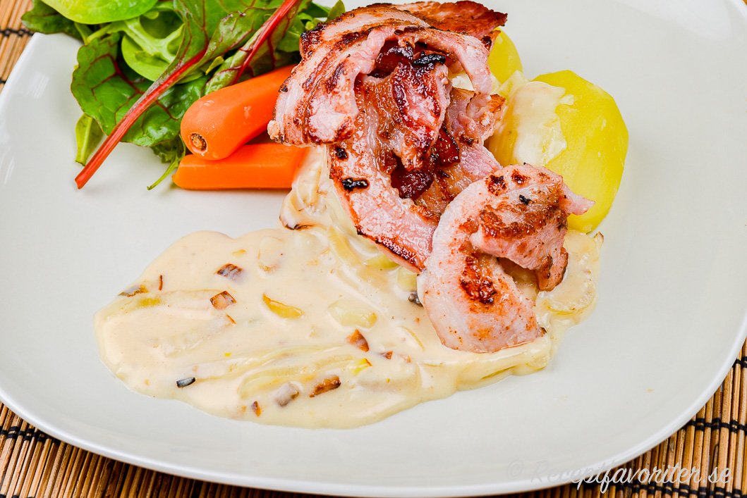 Stekt rimmat fläsk med löksås, grönsallad, kokt morot och potatis på tallrik. Stekt rimmat fläsk med löksås, grönsallad, kokt morot och potatis på tallrik.