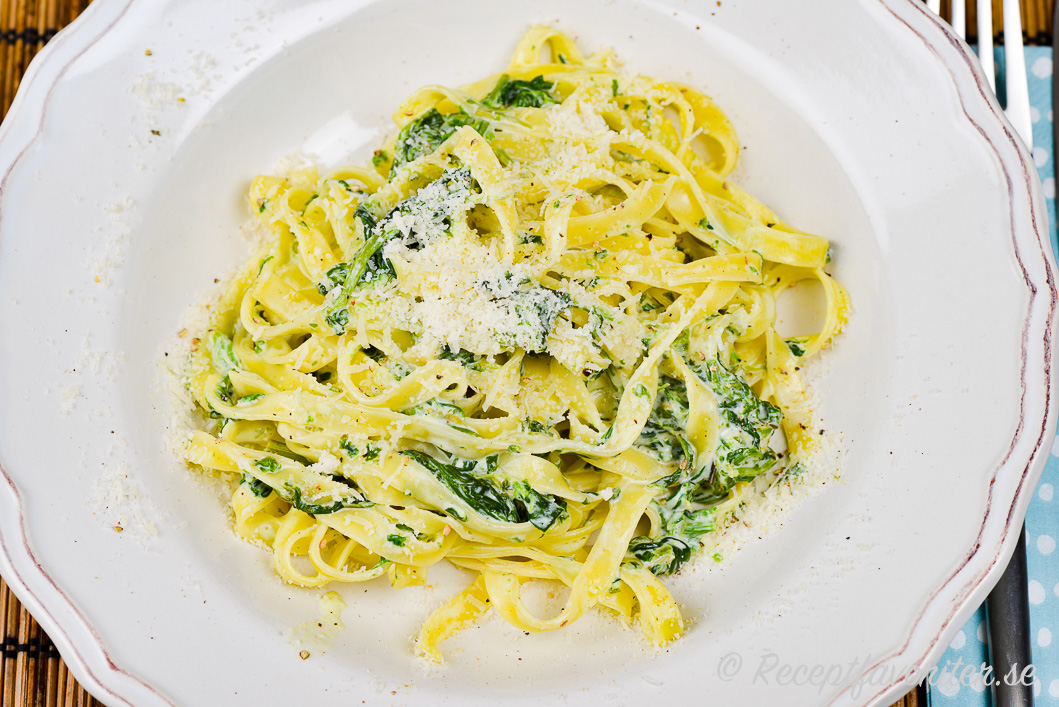 Pasta som tagliatelle med spenat och mascarpone i djup tallrik Pasta som tagliatelle med spenat och mascarpone i djup tallrik