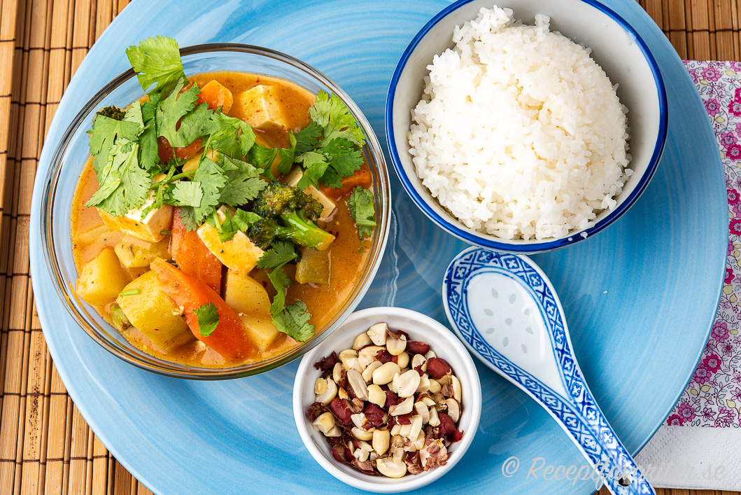 Vegomassaman med tofu och tillbehör på tallrik i skålar Vegomassaman med tofu och tillbehör på tallrik i skålar