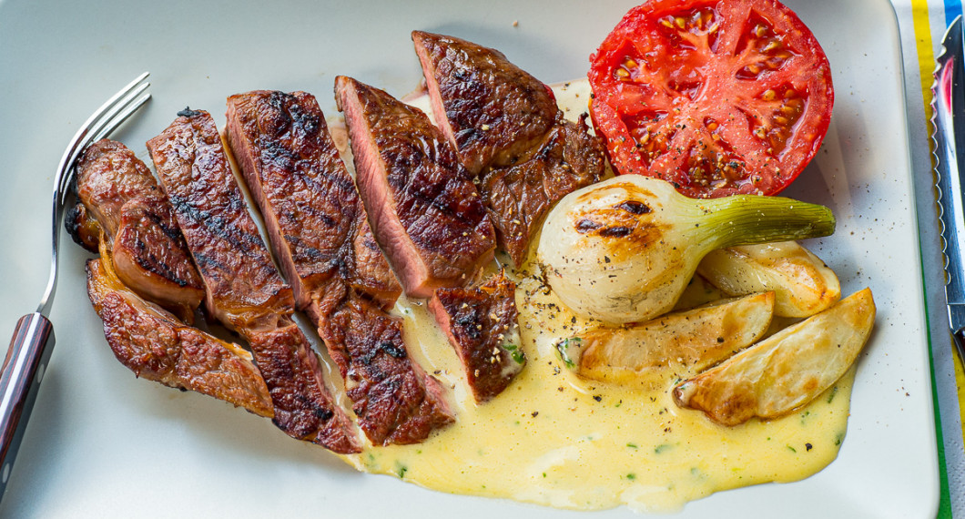 Grillad entrecote med bearnaisesås, grillad tomat, knipplök och klyftpotatis. 