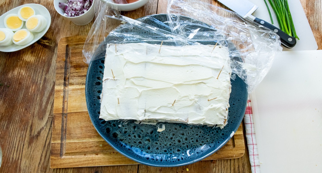 Botten till smörgåstårtan förbereds med kesella på fat