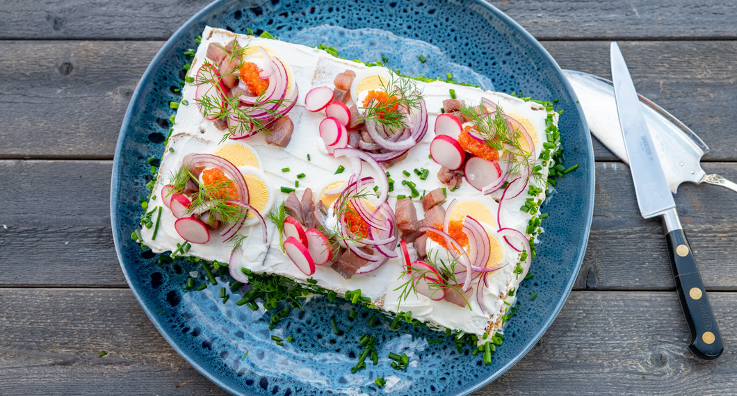 Smörgåstårtan garnerad av matjessill och massor med gott på fat