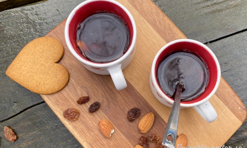 Slånbärsglögg i koppar med russin och mandlar. 